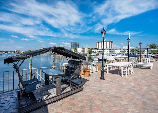 view of patio / terrace featuring a view of city and a water view