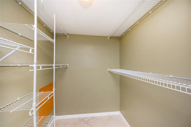 walk in closet with tile patterned floors