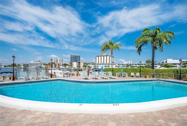 pool featuring a view of city, fence, and a patio