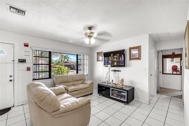 living area featuring visible vents, a textured ceiling, and light tile patterned floors