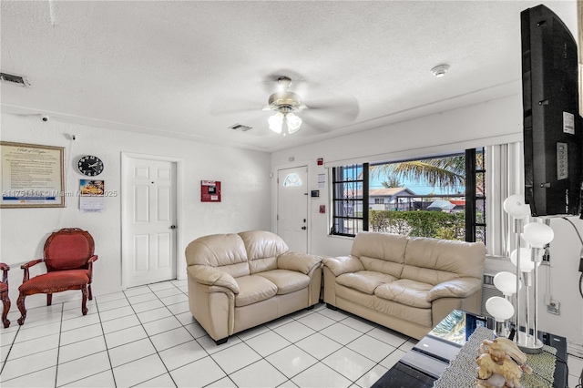 living area with visible vents, ceiling fan, a textured ceiling, and light tile patterned flooring