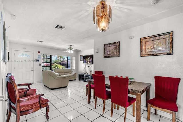 dining area featuring a textured wall, visible vents, a textured ceiling, and light tile patterned flooring