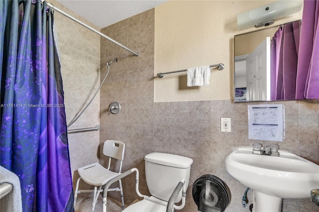 bathroom featuring toilet, a shower with curtain, tile walls, and a sink