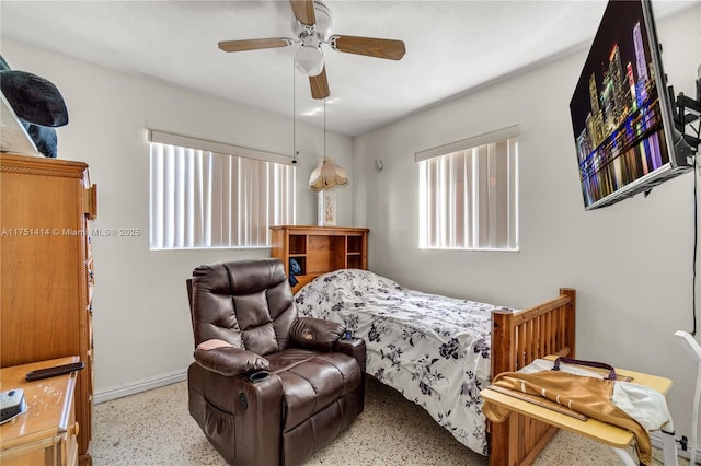 bedroom featuring baseboards, a ceiling fan, and speckled floor