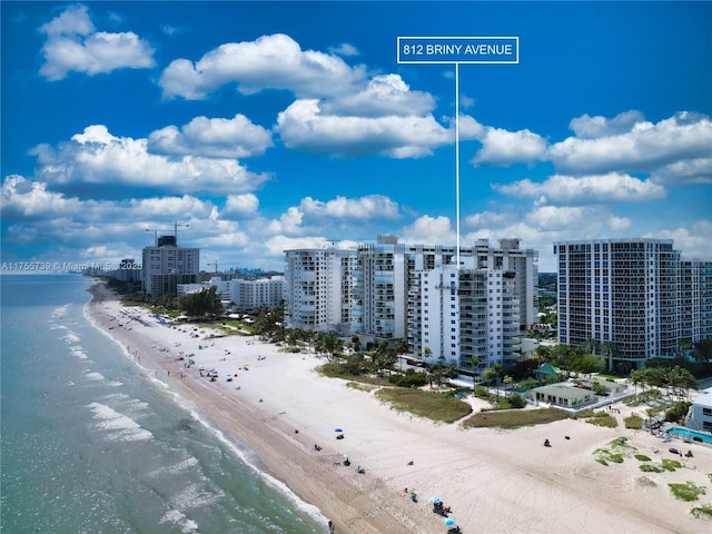 aerial view with a water view, a view of city, and a beach view