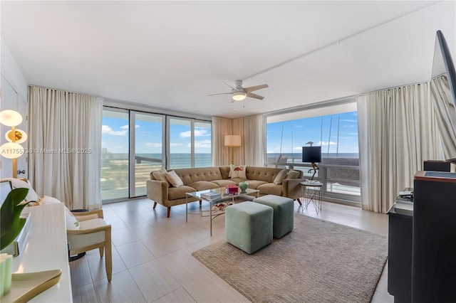 living area featuring light tile patterned floors, expansive windows, and a ceiling fan