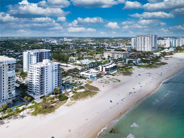 drone / aerial view featuring a view of the beach, a water view, and a view of city