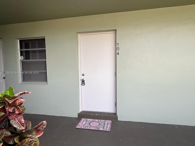 property entrance with stucco siding