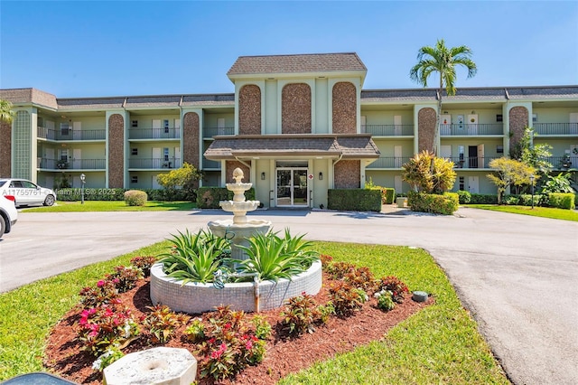 view of building exterior with curved driveway