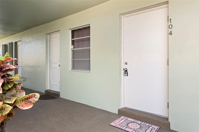 doorway to property featuring stucco siding