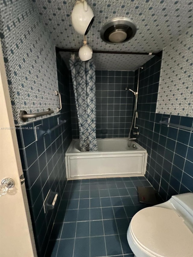 bathroom featuring toilet, tile patterned flooring, tile walls, and bathing tub / shower combination