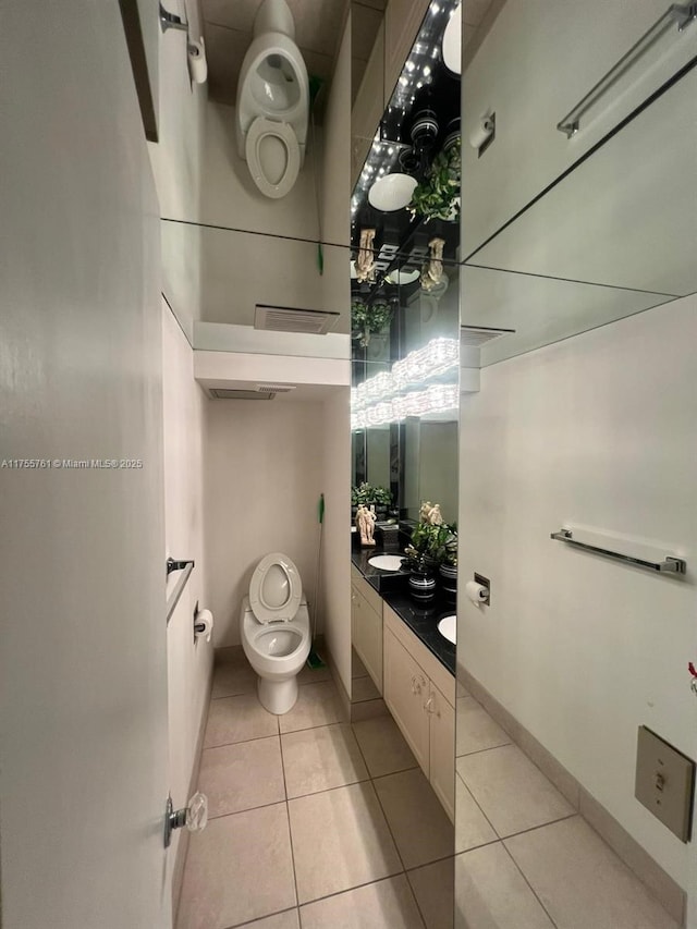 bathroom with baseboards, vanity, toilet, and tile patterned floors