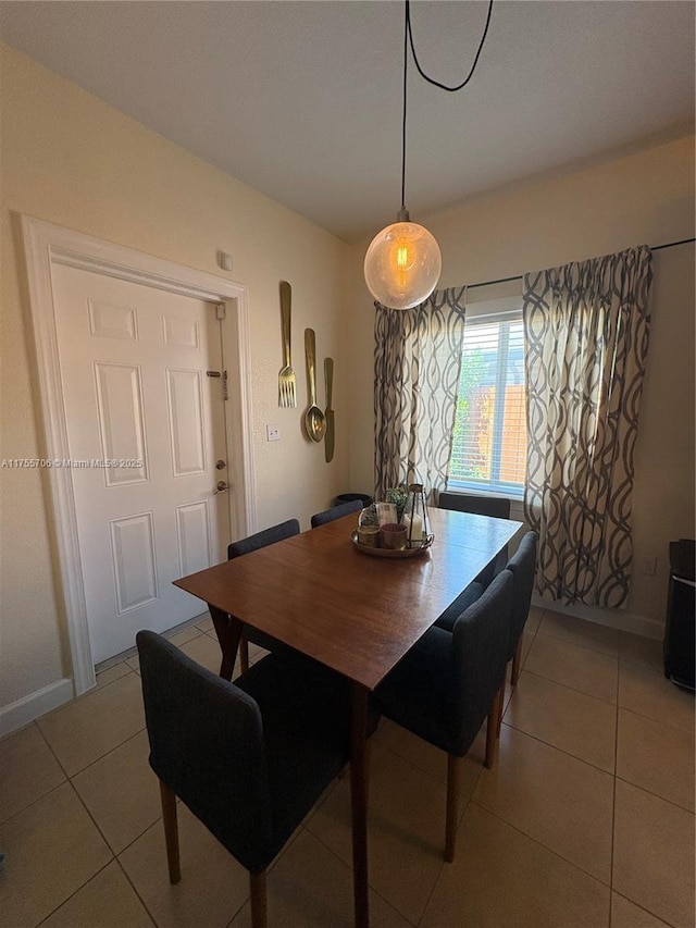 dining space featuring light tile patterned floors and baseboards