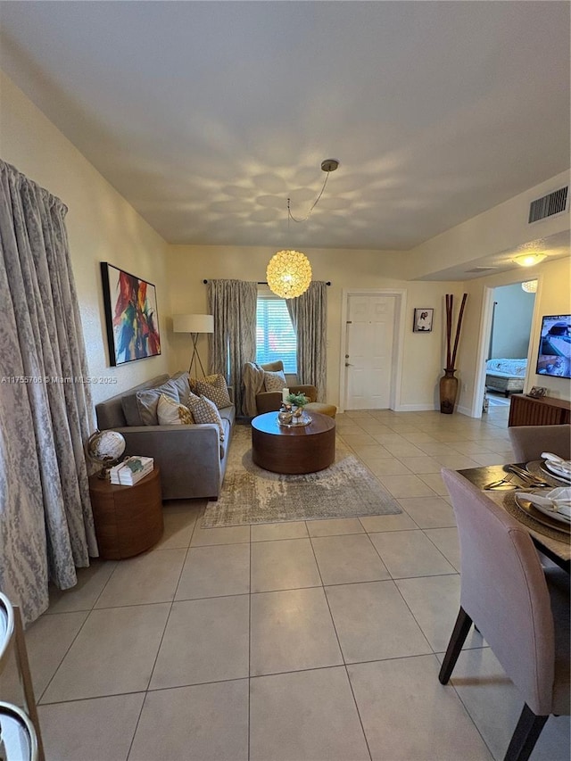 living room with light tile patterned floors, a chandelier, and visible vents