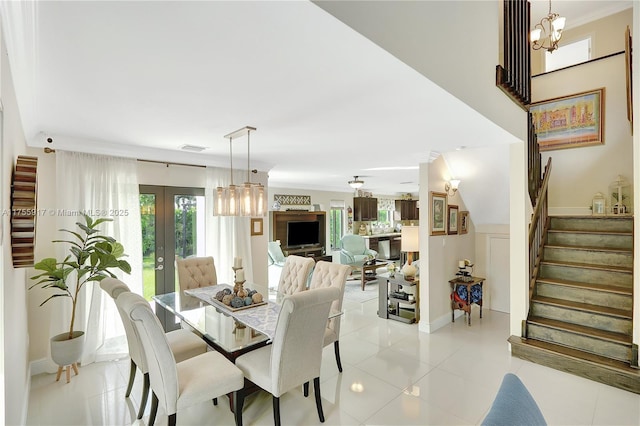 dining room featuring ornamental molding, french doors, light tile patterned floors, and stairs