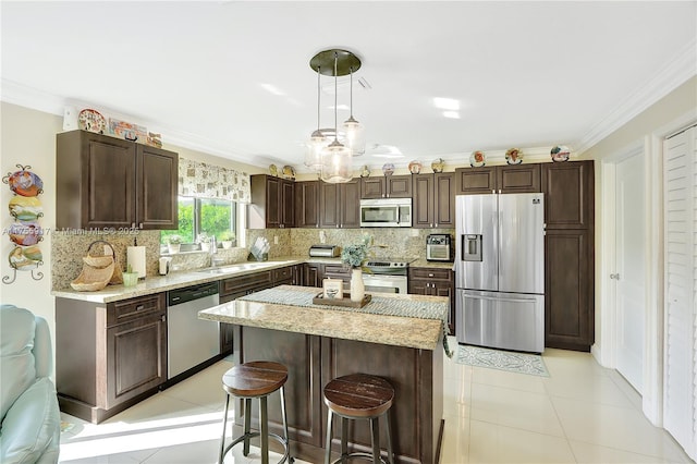 kitchen with ornamental molding, dark brown cabinets, appliances with stainless steel finishes, and a sink