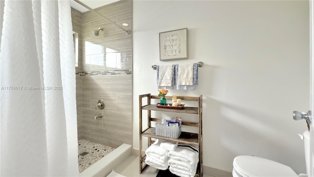 bathroom featuring a tile shower and toilet