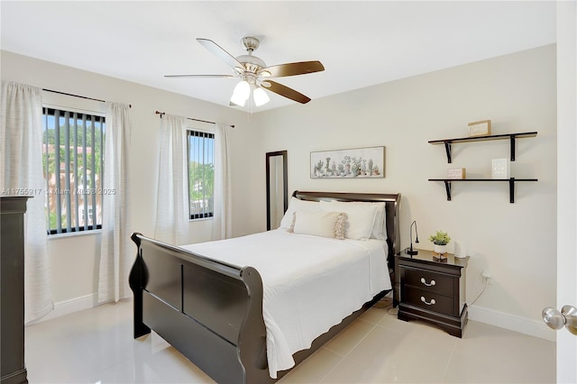 bedroom featuring a ceiling fan, baseboards, and light tile patterned floors