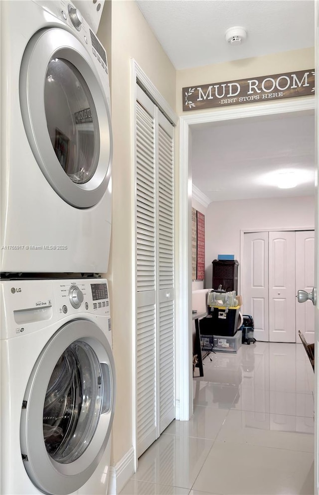 washroom featuring laundry area, stacked washing maching and dryer, and tile patterned floors