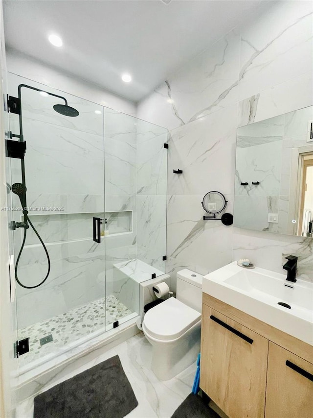 bathroom featuring marble finish floor, tile walls, a marble finish shower, toilet, and vanity