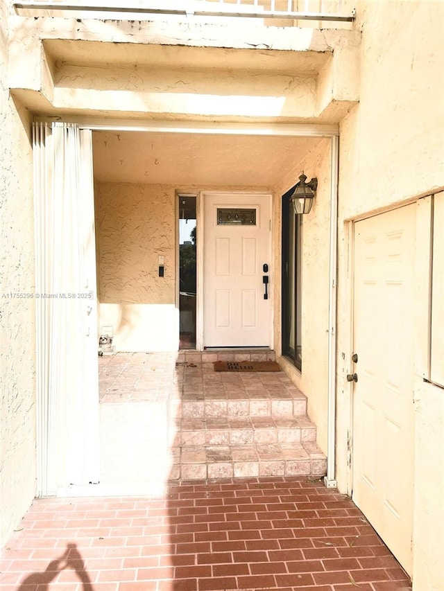 view of exterior entry featuring stucco siding