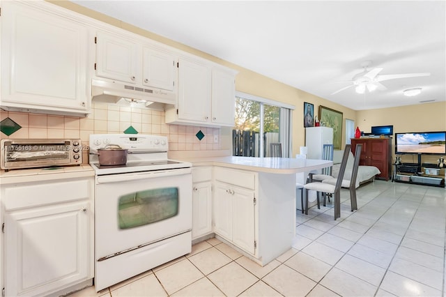 kitchen with white electric stove, under cabinet range hood, a peninsula, light countertops, and tasteful backsplash