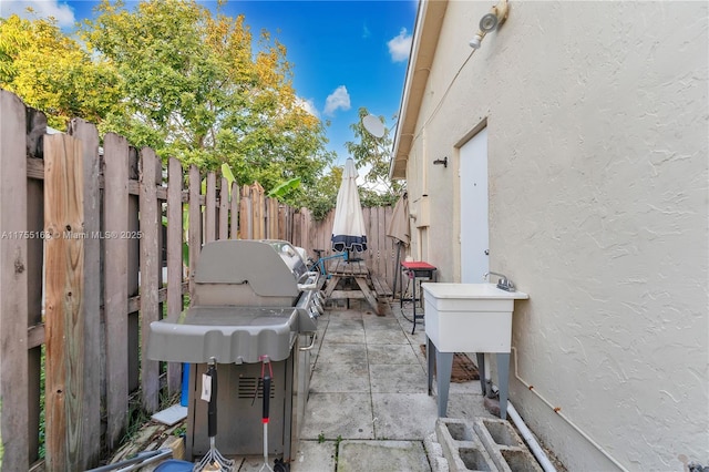 view of patio / terrace featuring fence and a grill