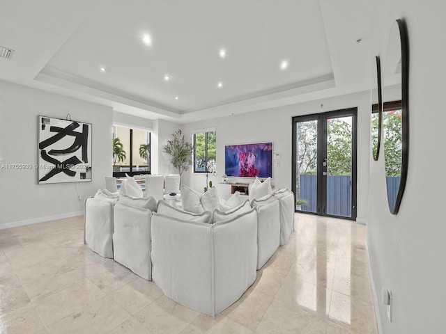 living room with a tray ceiling, french doors, recessed lighting, visible vents, and baseboards