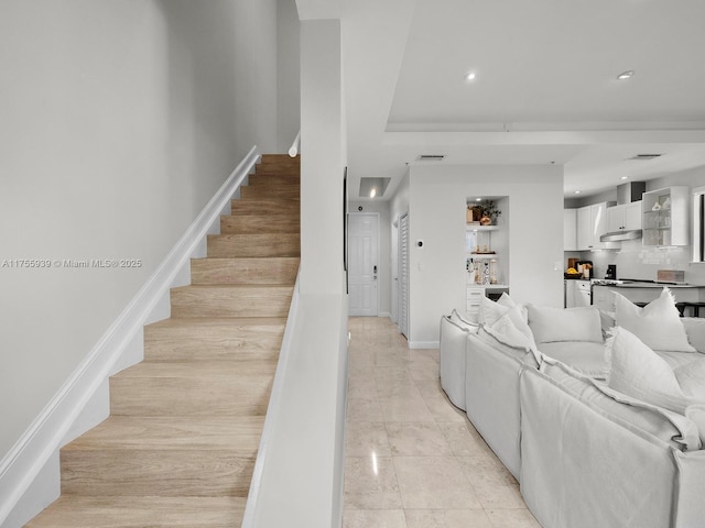 living room featuring light tile patterned floors, recessed lighting, visible vents, baseboards, and stairs