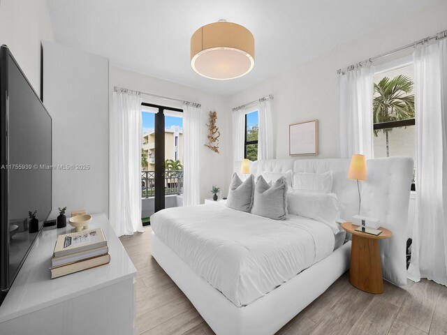 bedroom with light wood-style floors and access to outside