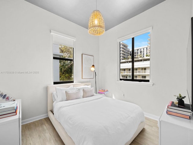 bedroom with light wood-type flooring and baseboards