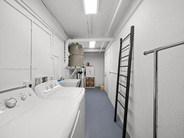 clothes washing area featuring a sink, laundry area, water heater, and washer and dryer