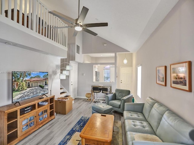 living room with high vaulted ceiling, visible vents, a ceiling fan, light wood-style floors, and stairway