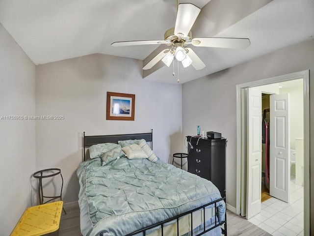 bedroom featuring light wood-style floors, baseboards, vaulted ceiling, and a ceiling fan