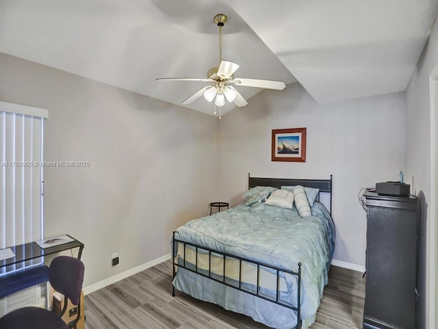 bedroom with lofted ceiling, ceiling fan, light wood-type flooring, and baseboards