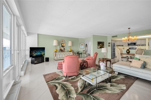 living room featuring visible vents, a notable chandelier, a textured ceiling, and light tile patterned floors