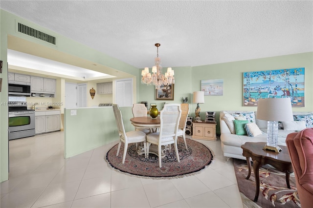 dining space featuring an inviting chandelier, light tile patterned floors, visible vents, and a textured ceiling