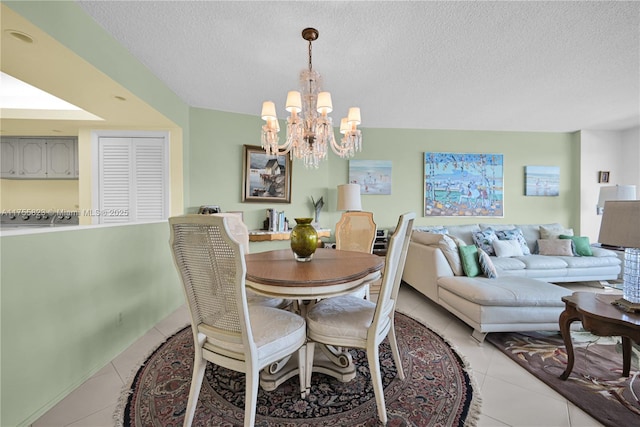 dining area featuring a textured ceiling, an inviting chandelier, and light tile patterned floors