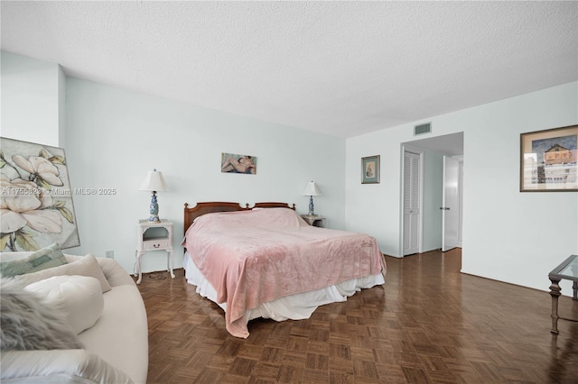 bedroom with visible vents and a textured ceiling