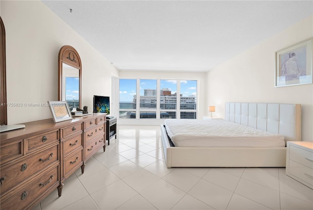 bedroom featuring light tile patterned floors and a textured ceiling