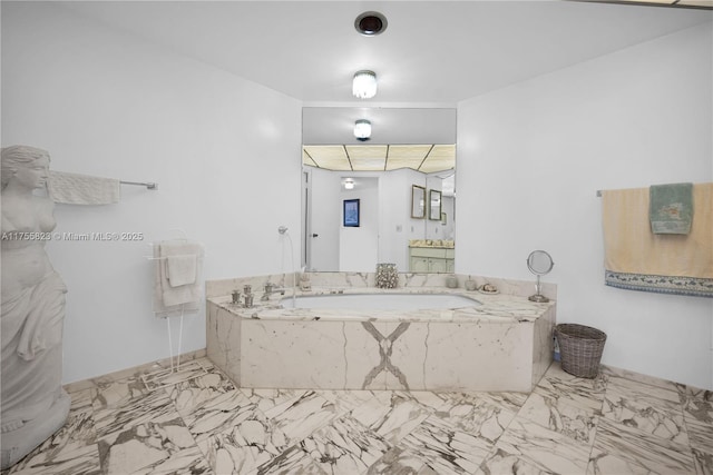 bathroom featuring marble finish floor, a bath, and vanity