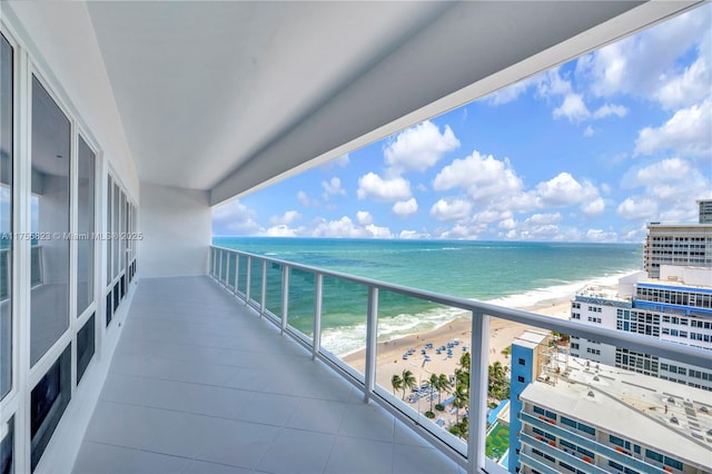 balcony featuring a beach view and a water view