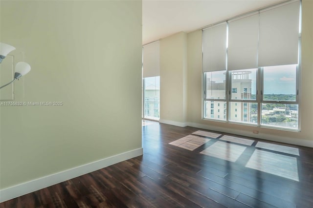 empty room featuring baseboards and wood finished floors