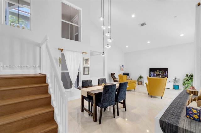 dining area with recessed lighting, visible vents, stairway, and a high ceiling