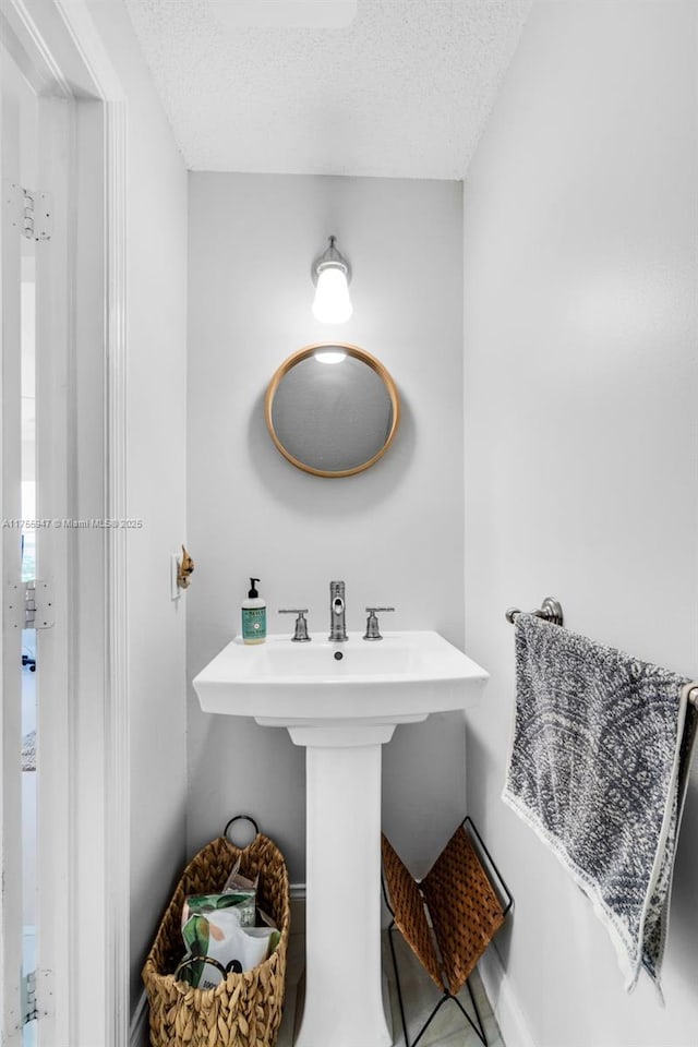 bathroom featuring a sink and a textured ceiling