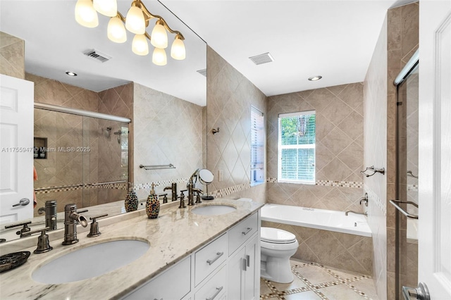 bathroom with a garden tub, a sink, visible vents, and a shower stall