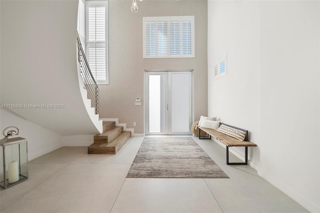 foyer entrance featuring stairs and baseboards