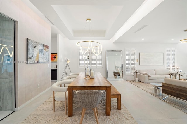 dining room with a chandelier and a raised ceiling