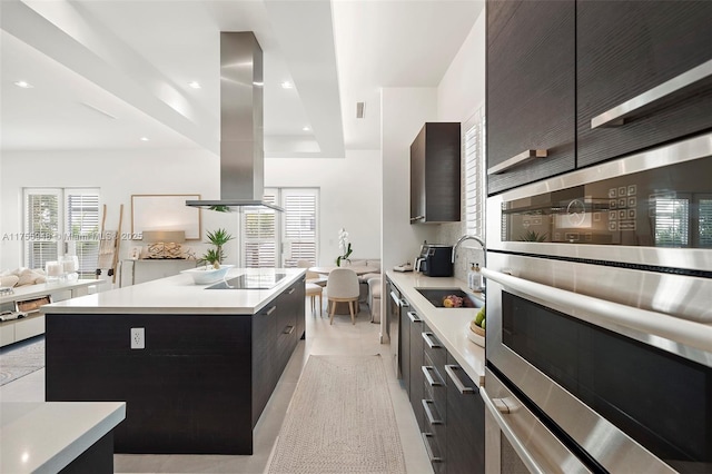 kitchen featuring stainless steel double oven, light countertops, a center island, modern cabinets, and island exhaust hood