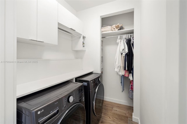 laundry room with washer and dryer, cabinet space, baseboards, and wood finished floors